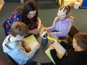 Author Sarah parkinson with boy writing a story of his own